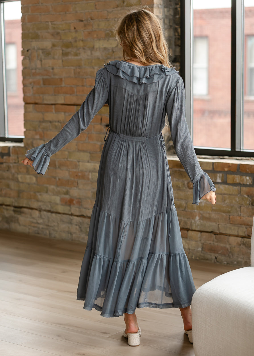 Back view of Free People midi dress with long sleeves, waist tie, ruffle neckline, and flowing tiered hem.