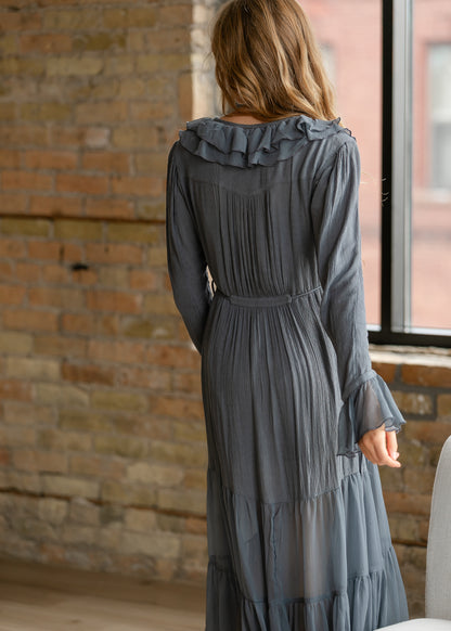 Back of slate blue-grey midi dress showing ruffle neckline, gathered back detail, tie waist, and tiered skirt.