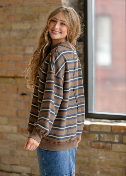 Back of brown striped pullover showing dropped shoulders, exposed center seam, and ribbed neckline.