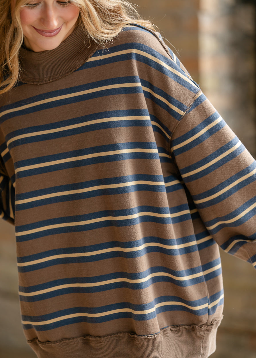 Brown Free People striped top with navy and cream stripes, oversized fit, and exposed seam details.