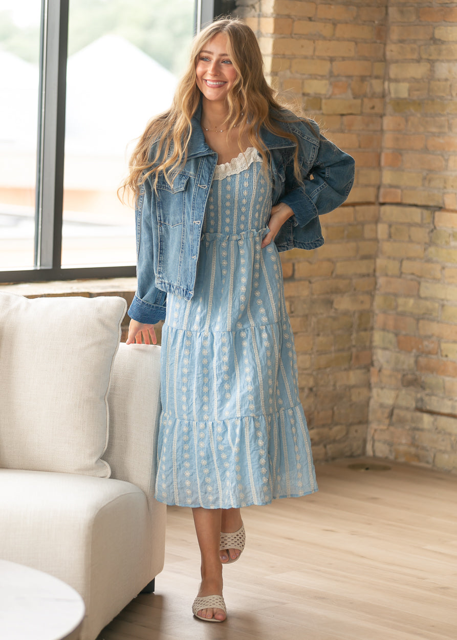 Free People River Wash denim jacket layered over a light blue embroidered maxi dress