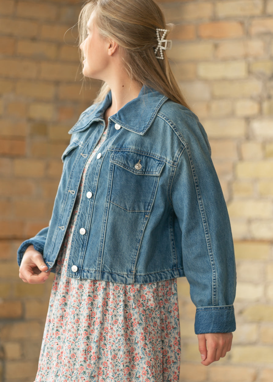 Side view of River Wash denim jacket styled over a floral midi dress
