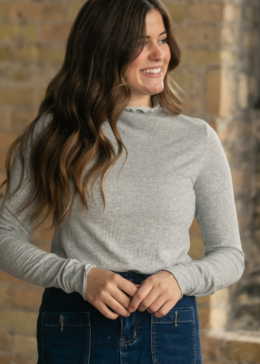 Free People gray seamless top showing textured knit detailing, a mock neckline, and long sleeves.