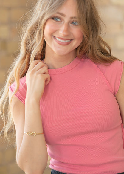 Close-up of strawberry pink ribbed knit fabric with crew neckline and exposed seams
