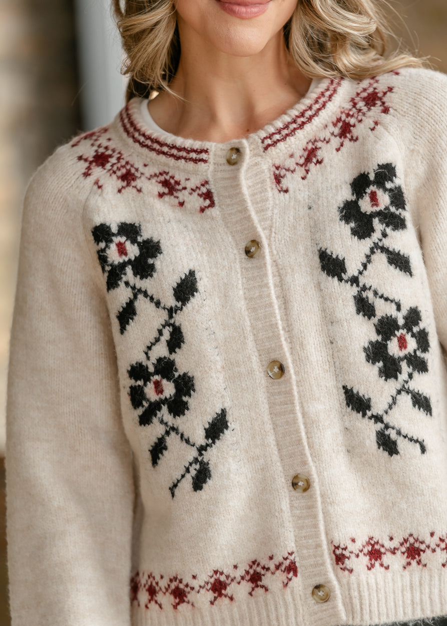 Ivory cardigan styled with a black midi skirt and red flats for a feminine layered look.