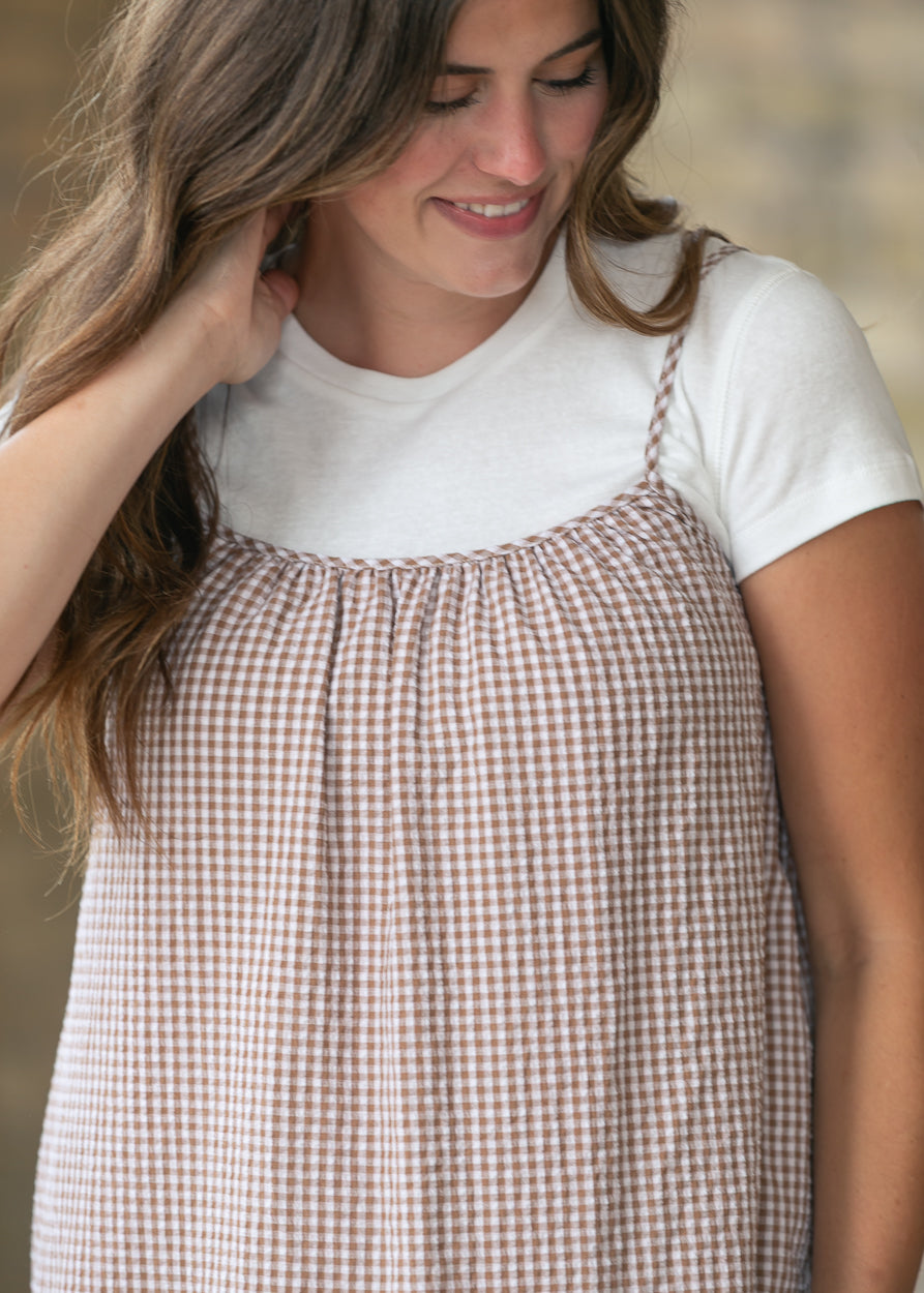 Close-up of the taupe gingham fabric and softly gathered neckline on the cami midi dress.