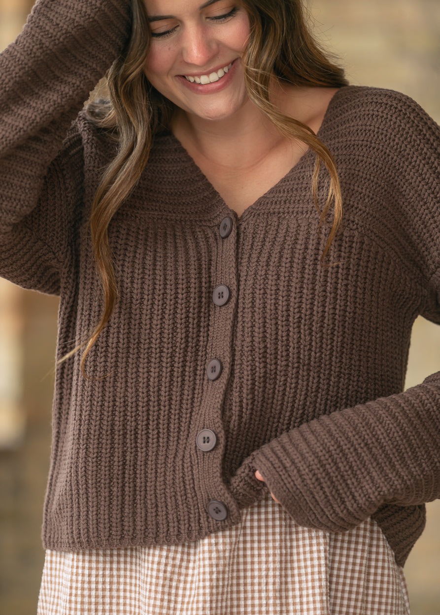 Close-up of the espresso knit cardigan featuring a V-neckline, ribbed texture, and button front.