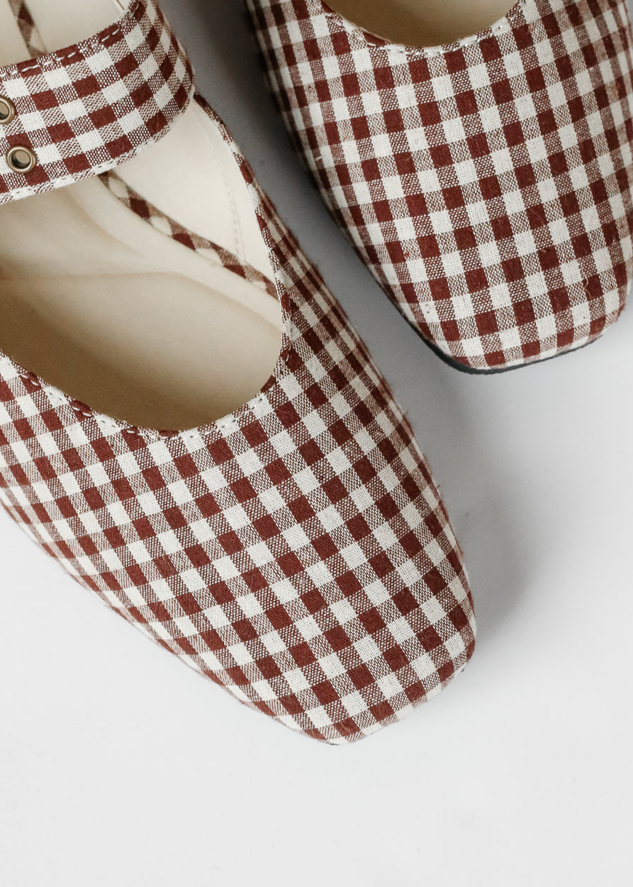 Close-up of brown gingham ballet flats showing square toe pattern and cream interior.
