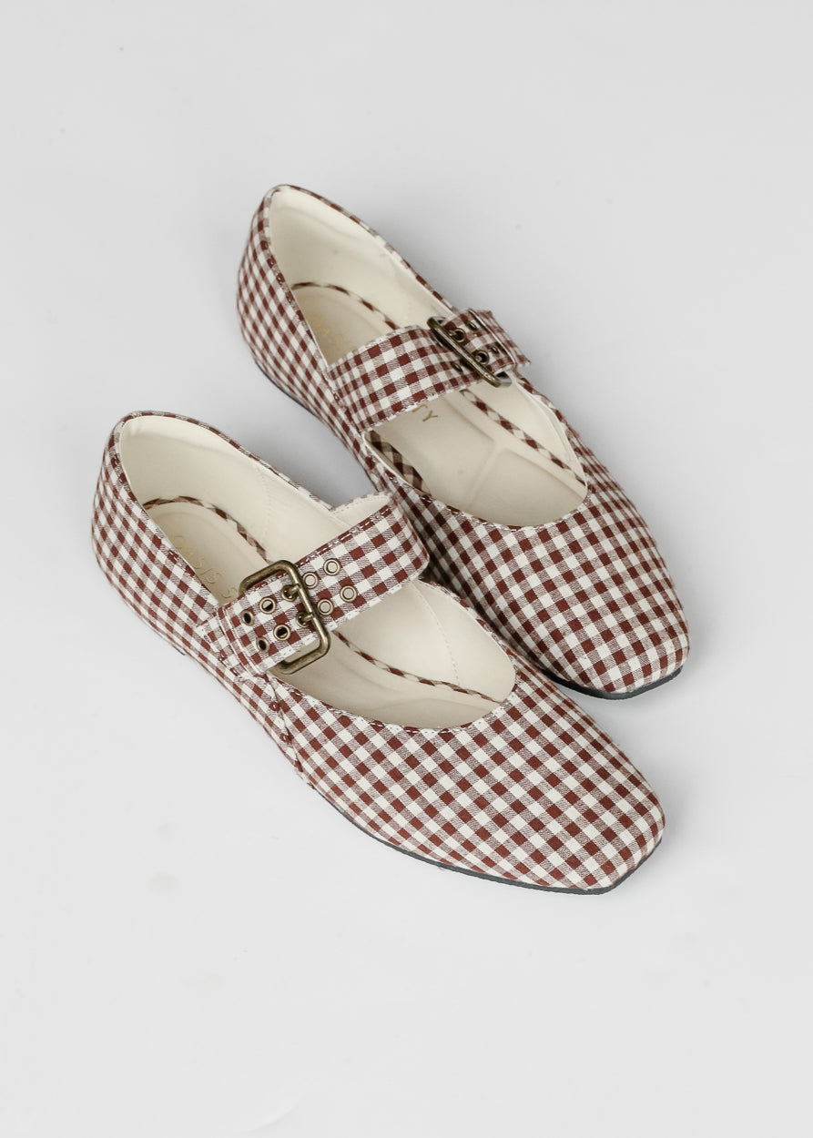 Brown gingham ballet flats with square toe, buckle strap, and cream lining on white background.