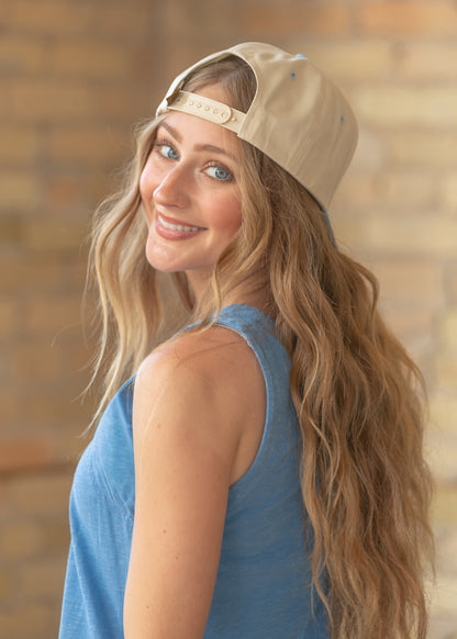 Back view of cream and blue trucker hat showing the structured crown and adjustable snapback closure