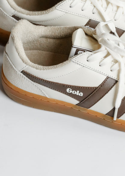 Close-up of brown Gola side stripe and logo on ivory Eagle '86 sneaker with gum sole.