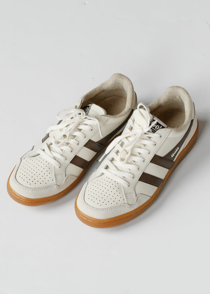 Ivory and brown Gola Eagle '86 sneakers with perforated toes, white laces, and gum soles on white background.