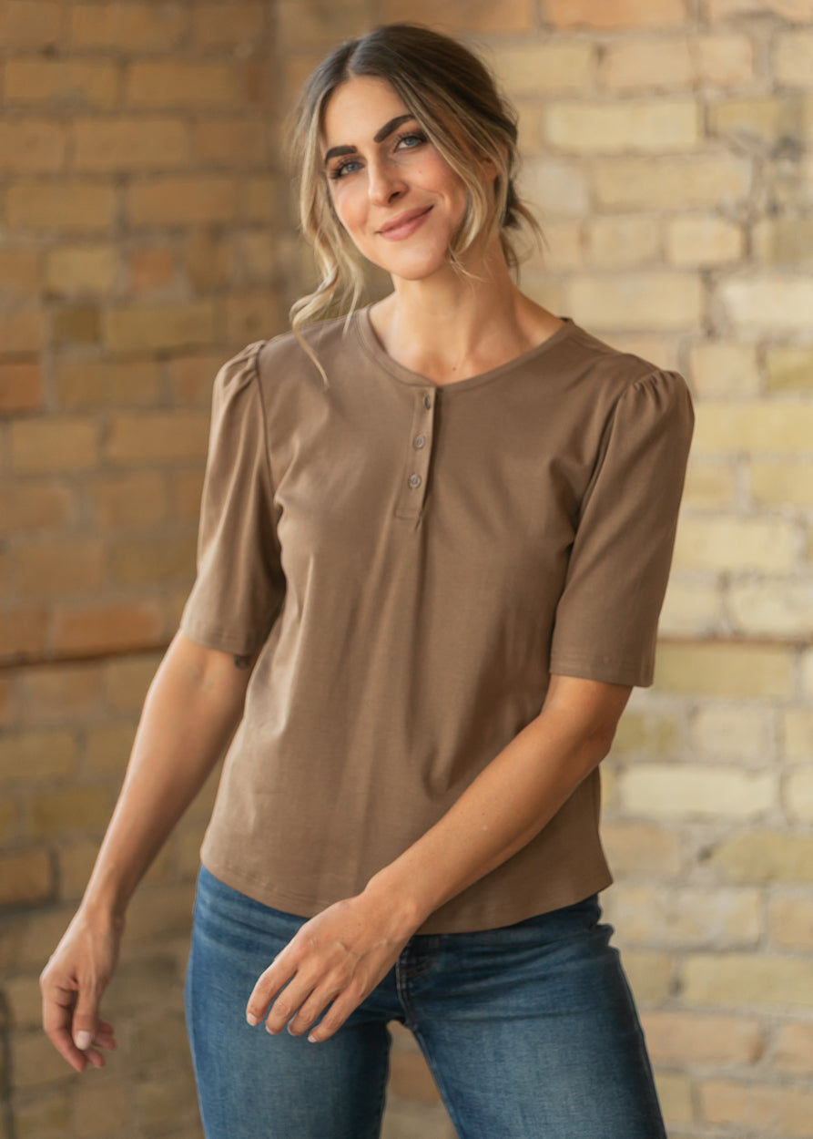 Brown Grace shirt showing functional buttons, puff shoulders, and relaxed hip-length silhouette.