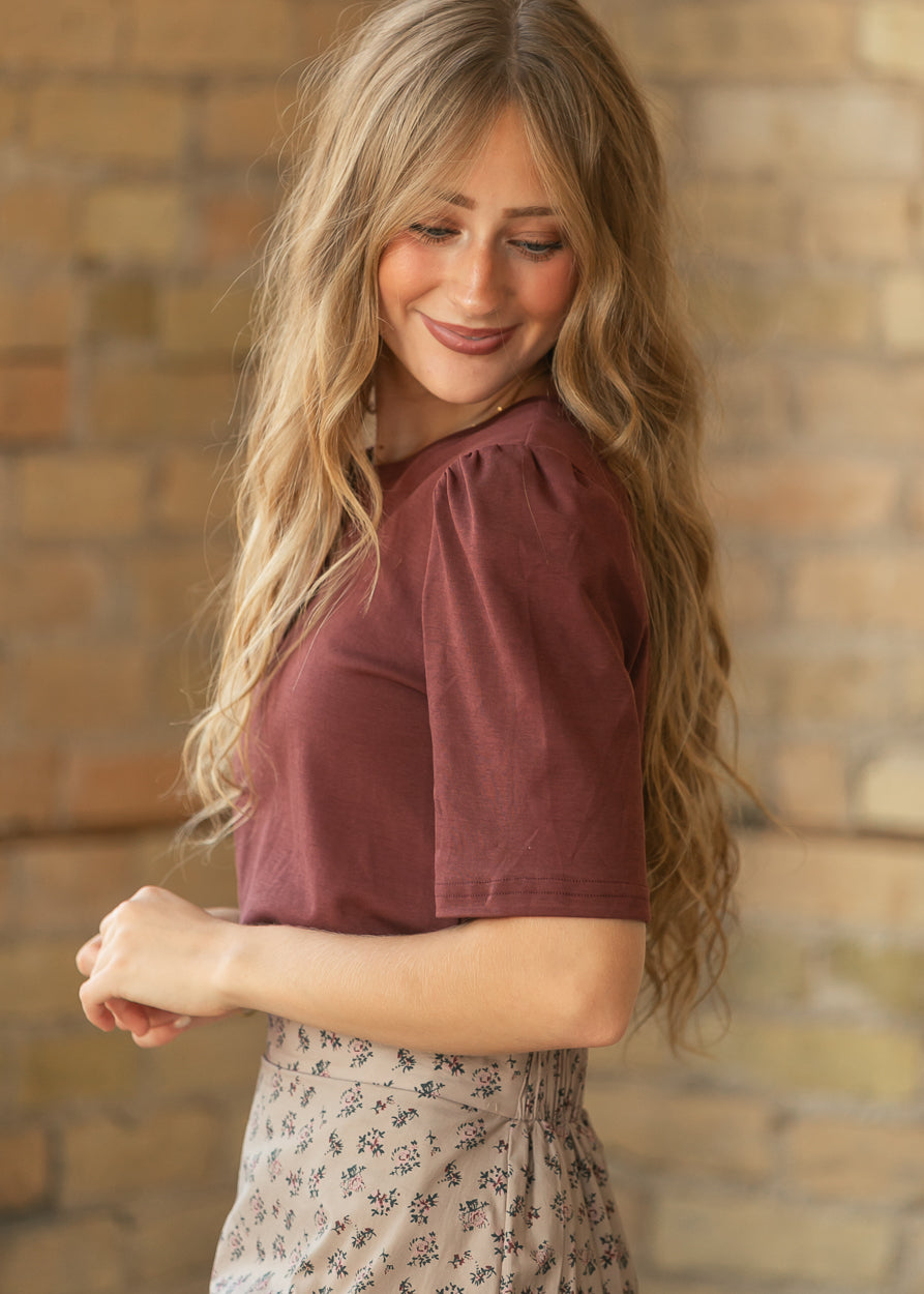 Side view of burgundy Grace shirt showing gathered puff shoulder and elbow-length sleeve.