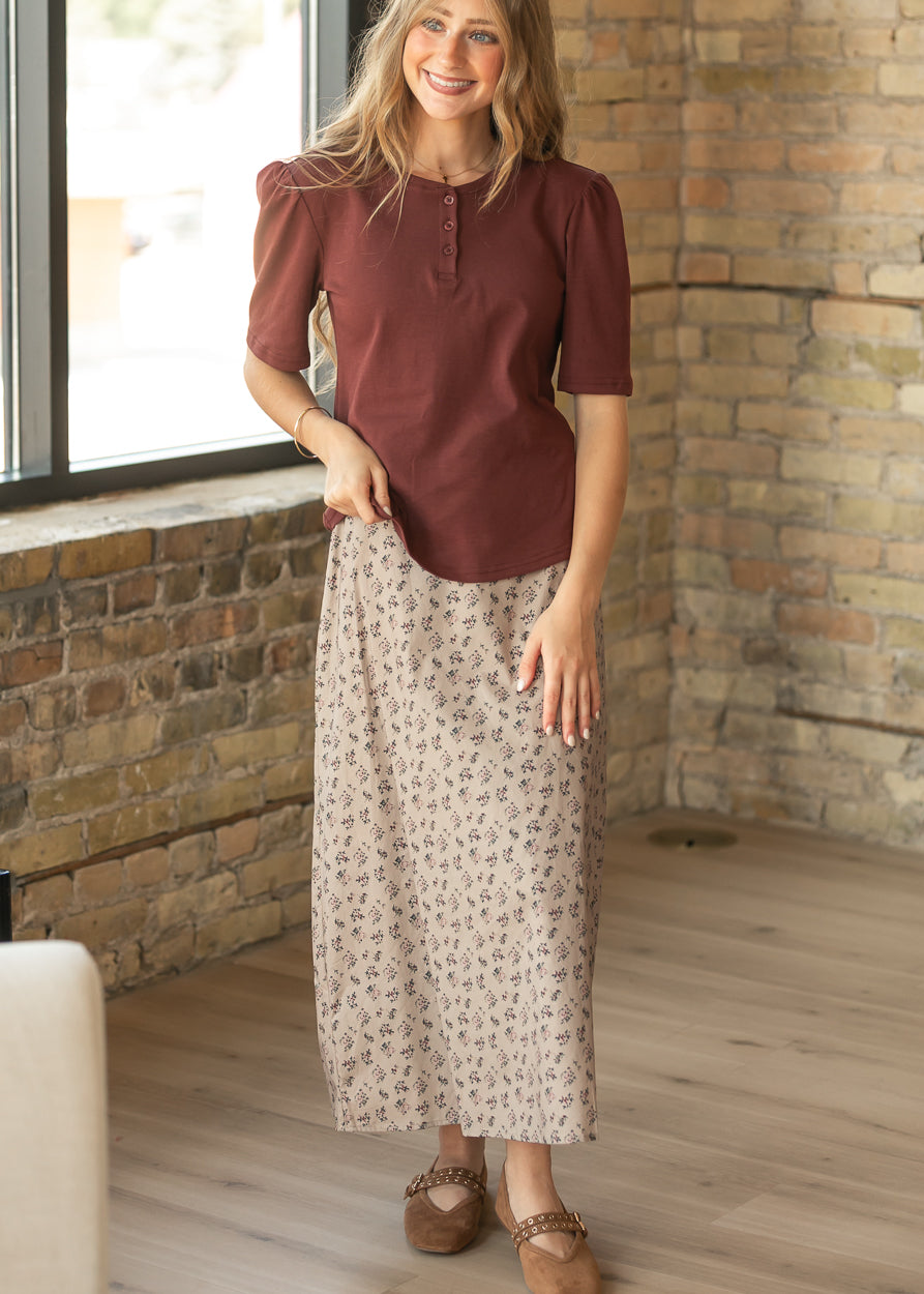 Burgundy Grace shirt worn untucked with a taupe floral maxi skirt, showing its hip-length fit.