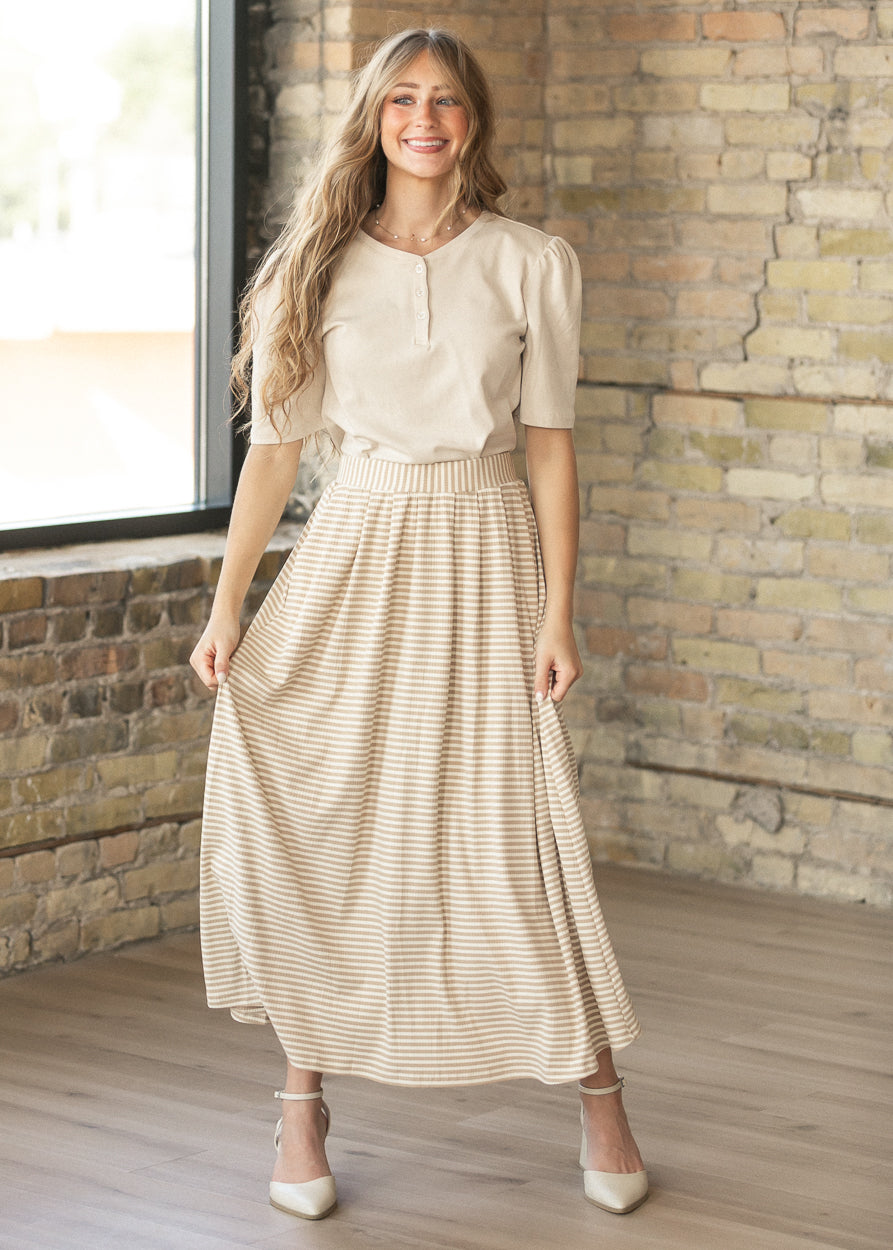 Cream Grace cotton button shirt with puffed elbow sleeves, styled with a taupe striped maxi skirt.