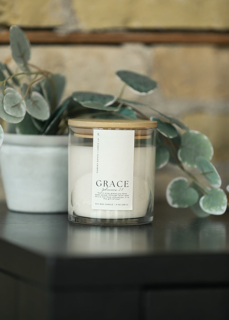Grace White Peach Blossom 9 oz. soy candle in a clear glass jar with white wax and natural wood lid.