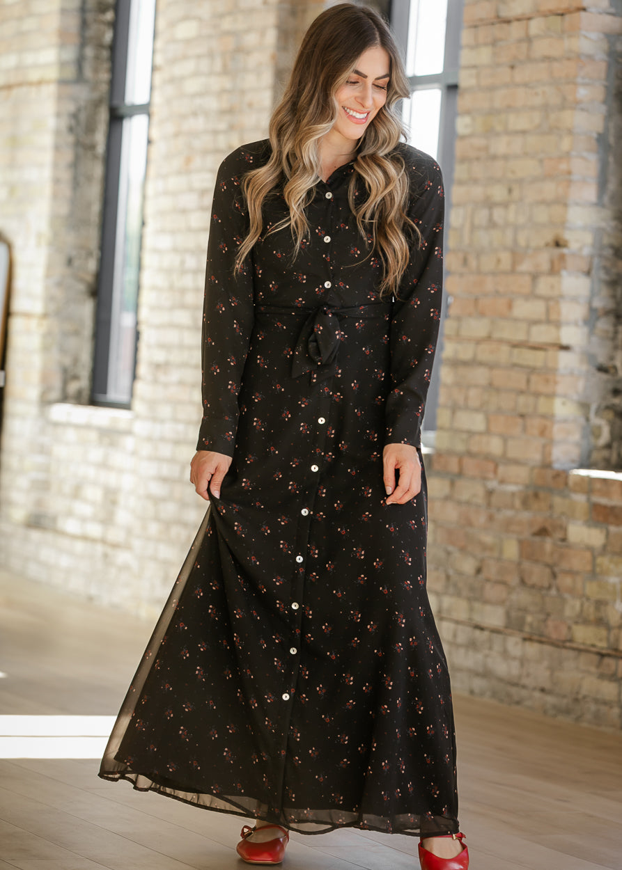 Gracelyn floral maxi dress in motion, showing its flowing black skirt, contrast buttons, and red flats.