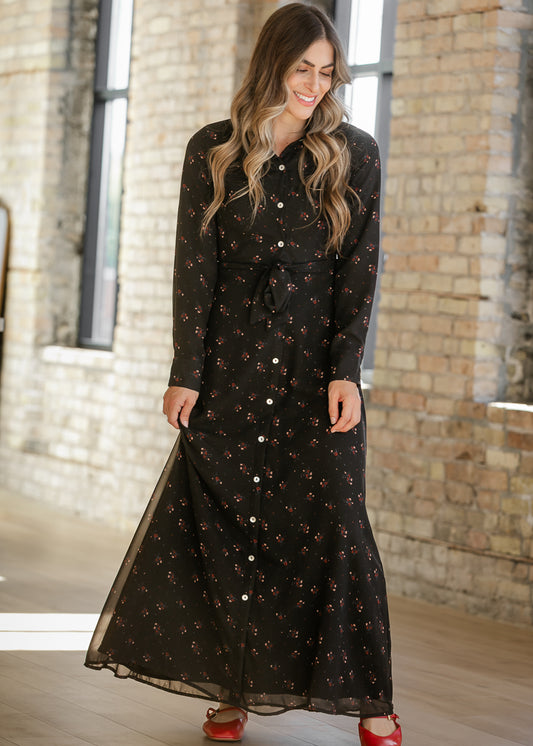 Gracelyn floral maxi dress in motion, showing its flowing black skirt, contrast buttons, and red flats.