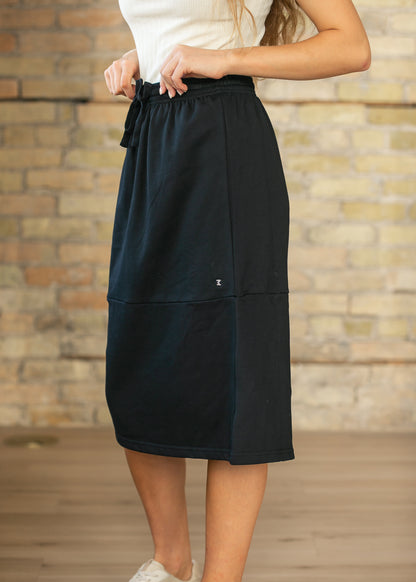 Black midi sweat skirt with elastic drawstring waist and midi hem, styled with a white tee and sneakers.