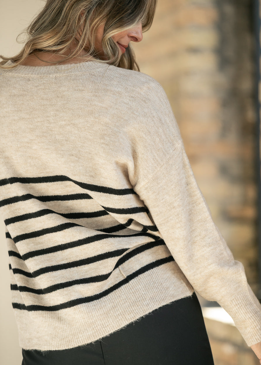Back of heather beige striped sweater showing ribbed neckline and dropped shoulder seam.