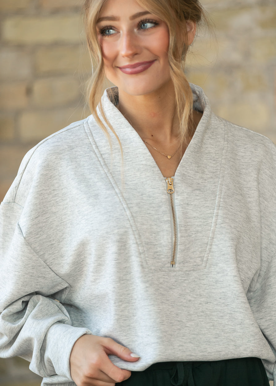 Close-up of the heather gray quarter zip sweatshirt's notched collar and quarter zip detail.