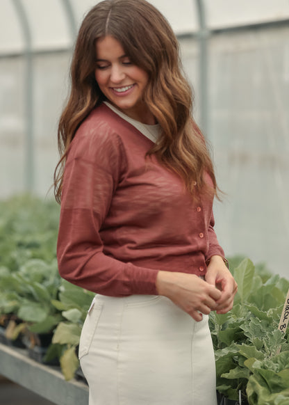 Lightweight rust cardigan paired with a cream maxi skirt and neutral heels