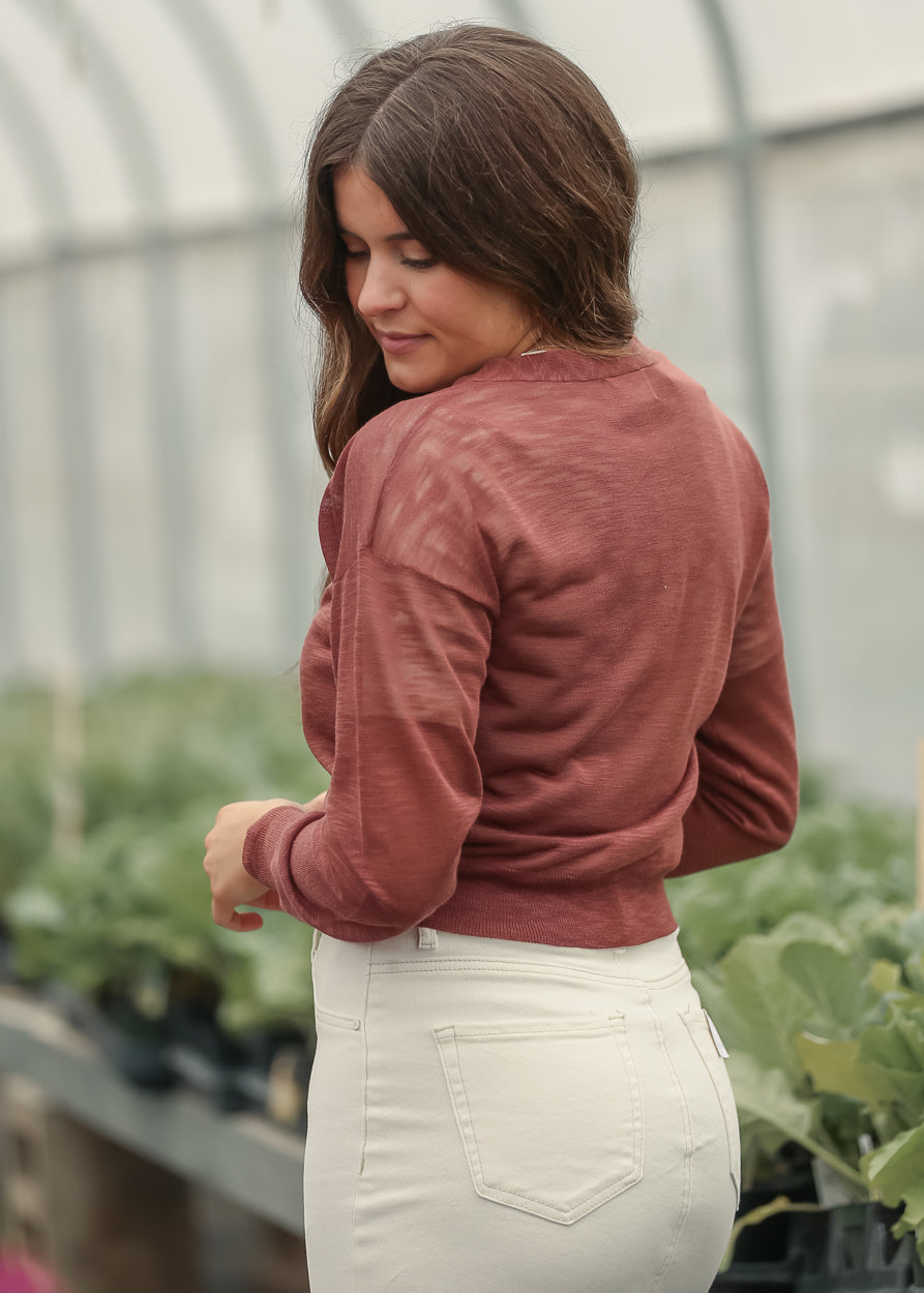 Rust cropped cardigan with lightweight long sleeves and ribbed hem detail