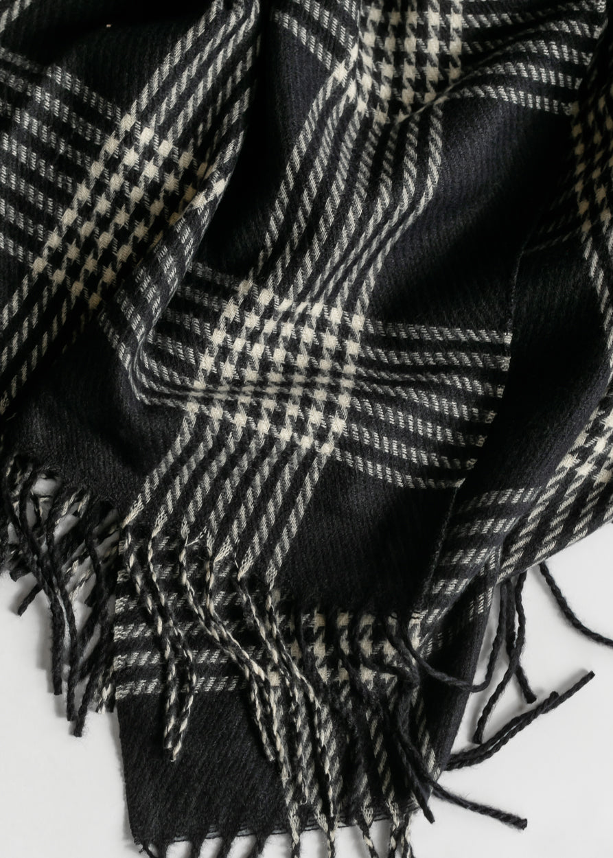 Black and white houndstooth plaid scarf showing soft woven texture and twisted fringe trim.