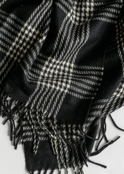 Black and white houndstooth plaid scarf showing soft woven texture and twisted fringe trim.