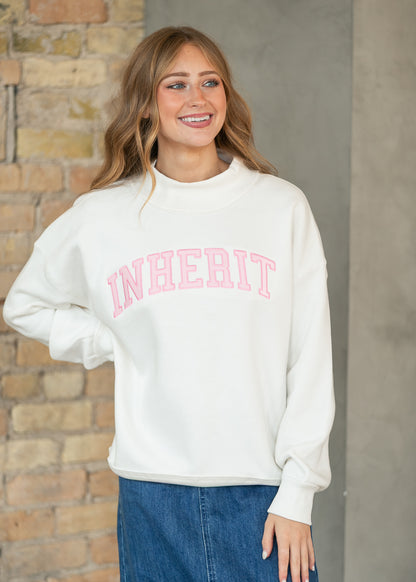 Cream mockneck sweatshirt with pink lettering, long sleeves, and relaxed silhouette.