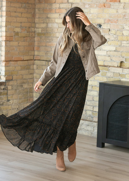 Black floral leaf maxi dress styled with a taupe lightweight denim jacket and ankle boots.