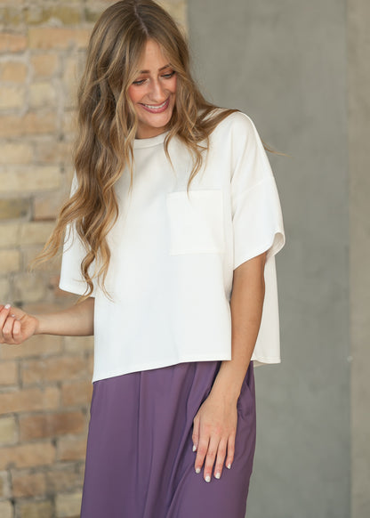 Ivory crew neck scuba top with loose boxy fit, styled with a purple skirt.