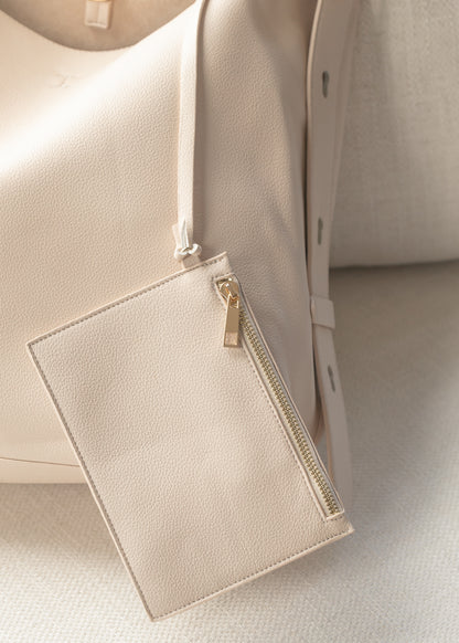 Ivory everyday tote bag featuring adjustable strap and gold-tone buckle detail.