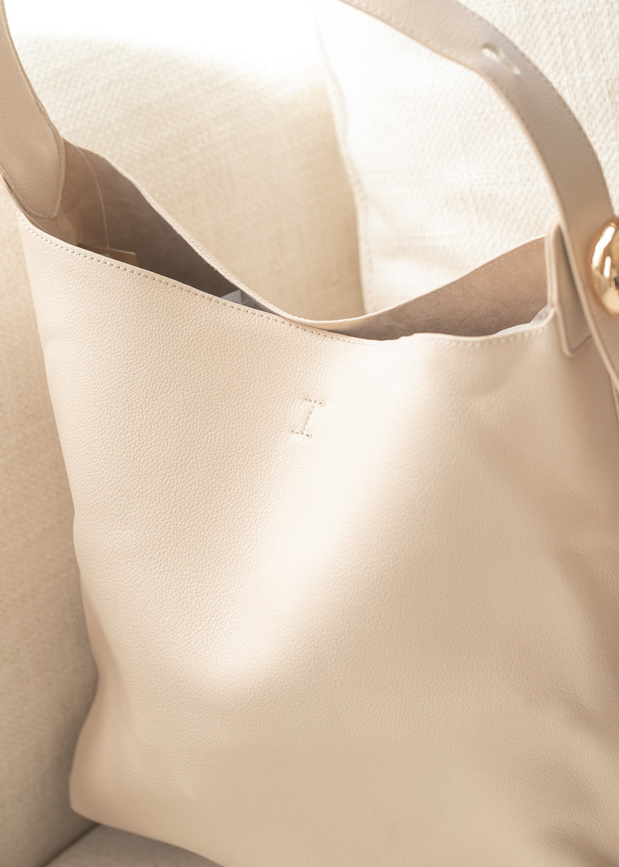 Ivory tote bag with spacious open-top design and soft structured silhouette.