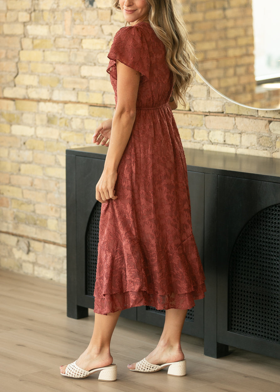 Rust floral jacquard midi dress from a back angle, styled with cream woven heels.