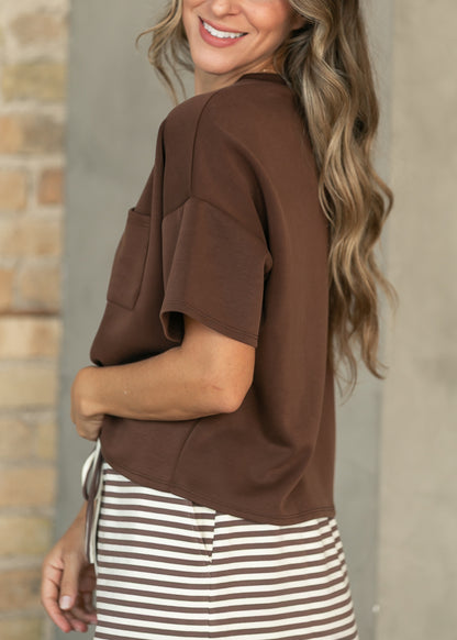 Side view of chocolate scuba top with relaxed short sleeves and a loose boxy silhouette.