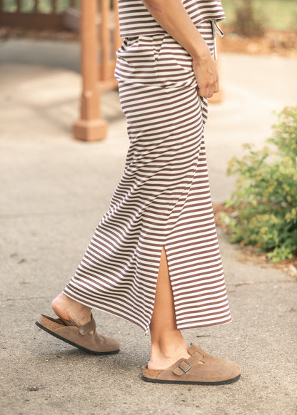 Side view of chocolate stripe knit maxi skirt showing the long side slit and straight silhouette.