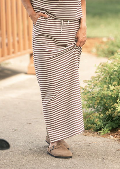 Chocolate stripe knit maxi skirt with drawstring waist and side pocket, styled outdoors.
