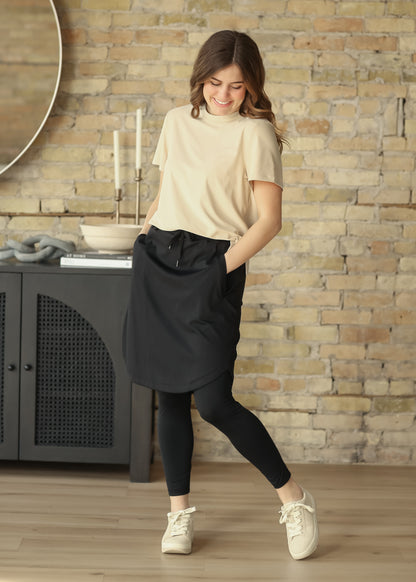 Black Kenedi athletic skirt with leggings, drawstring waist, and pockets styled for everyday movement.