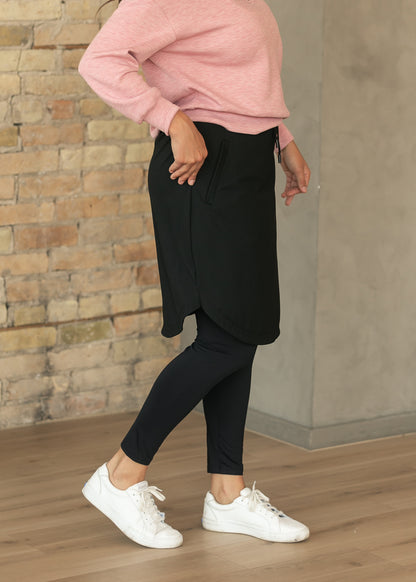 Black Kenedi sport skirt with curved hem and built-in leggings shown from the side.