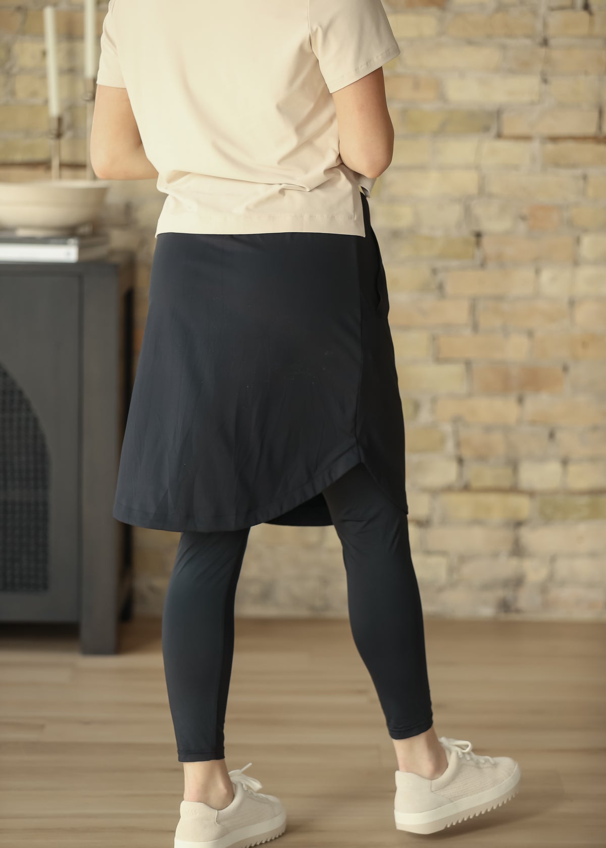 Back of black Kenedi sport skirt showing the curved hem and full-length built-in leggings.