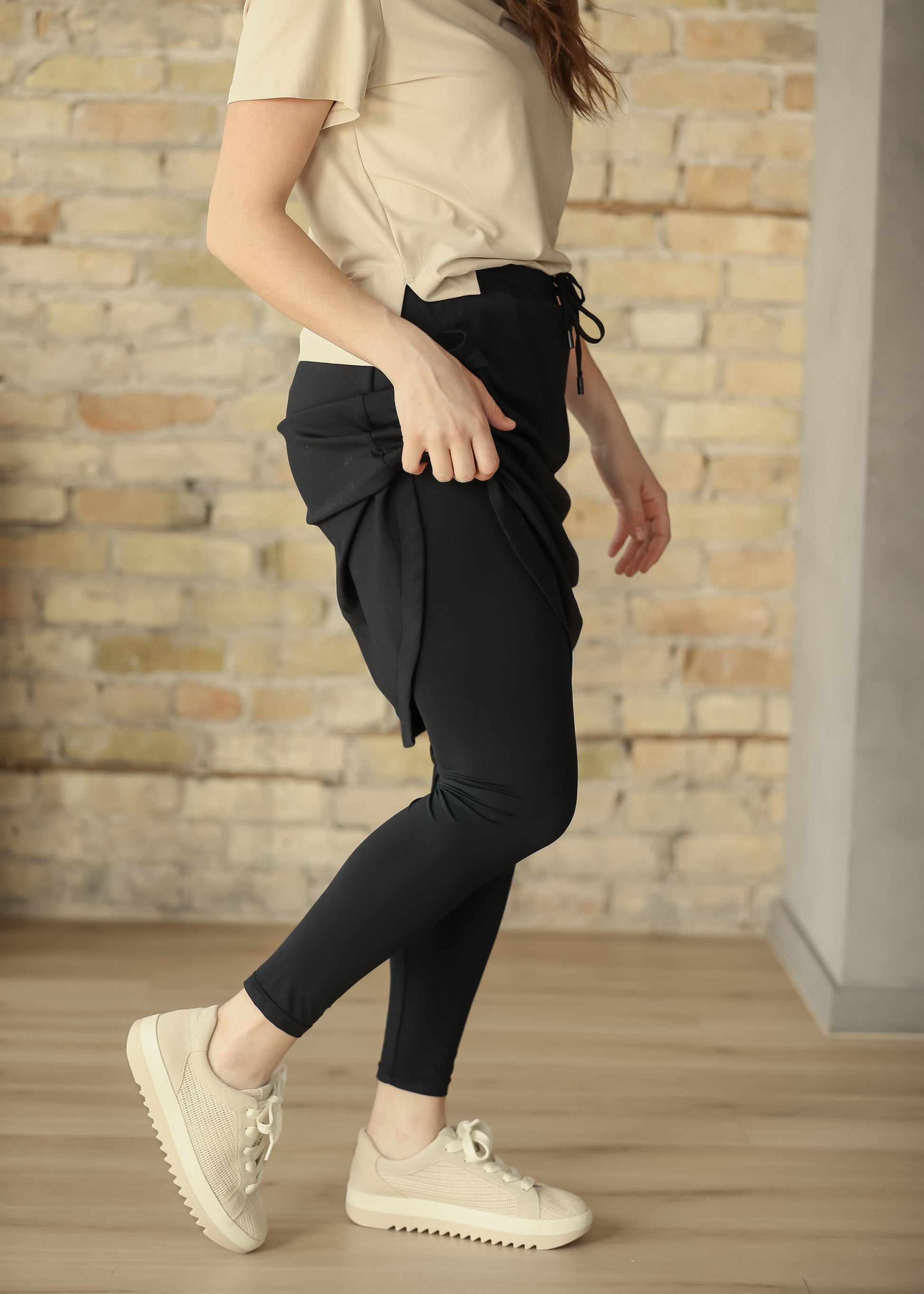 Black sport skirt lifted to show the smooth full-length leggings underneath.