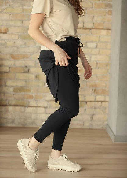 Black sport skirt lifted to show the smooth full-length leggings underneath.
