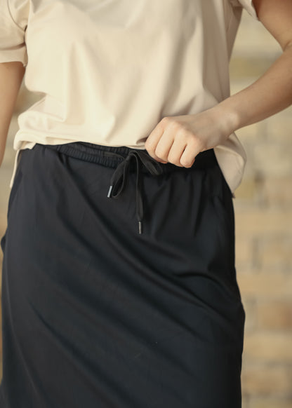 Close-up of black Kenedi sport skirt showing elastic waistband and functional drawstring.