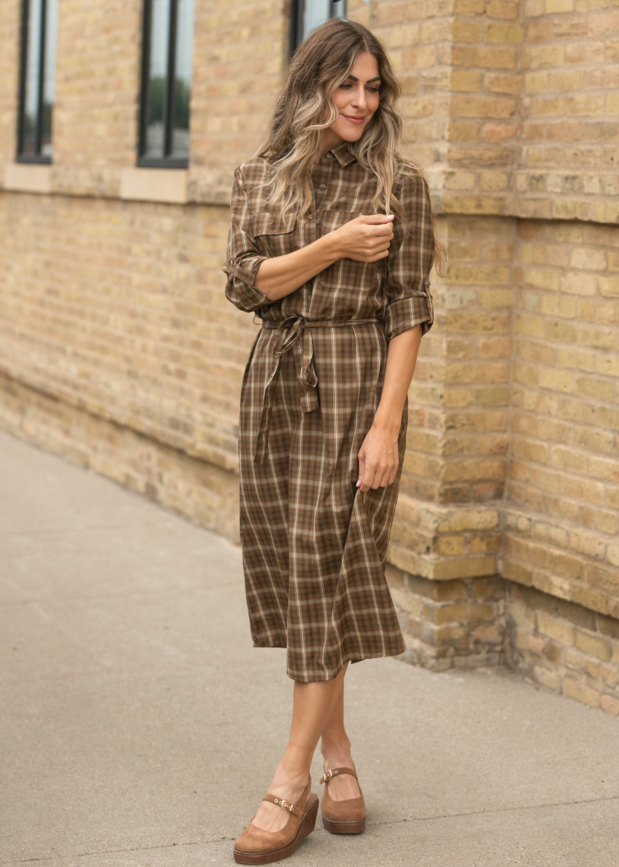 Kimberly brown plaid dress showing the button front, long sleeves, and softly gathered midi skirt.
