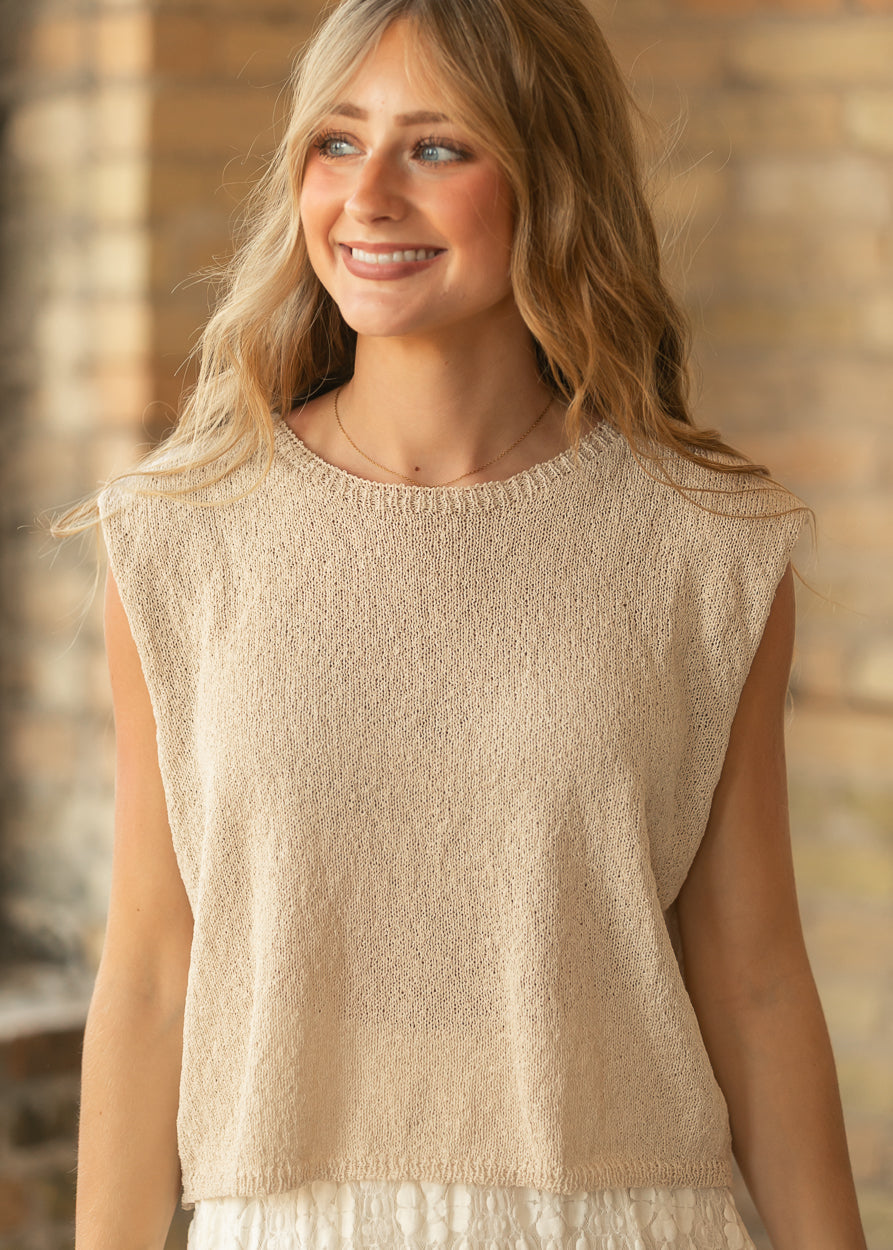 Beige sleeveless sweater top with relaxed fit, round neckline, and soft open-knit texture.