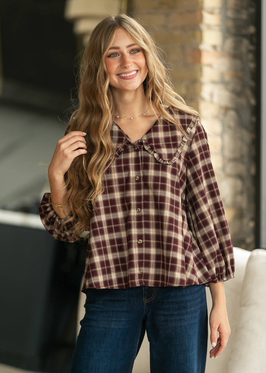 Front view of burgundy and cream plaid blouse with button-front detail and loose fit.