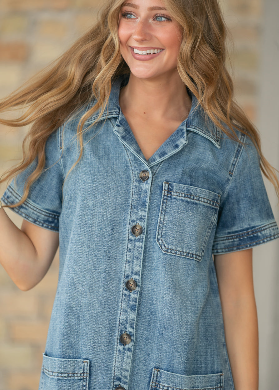 Close-up of button front placket and medium wash denim fabric.
