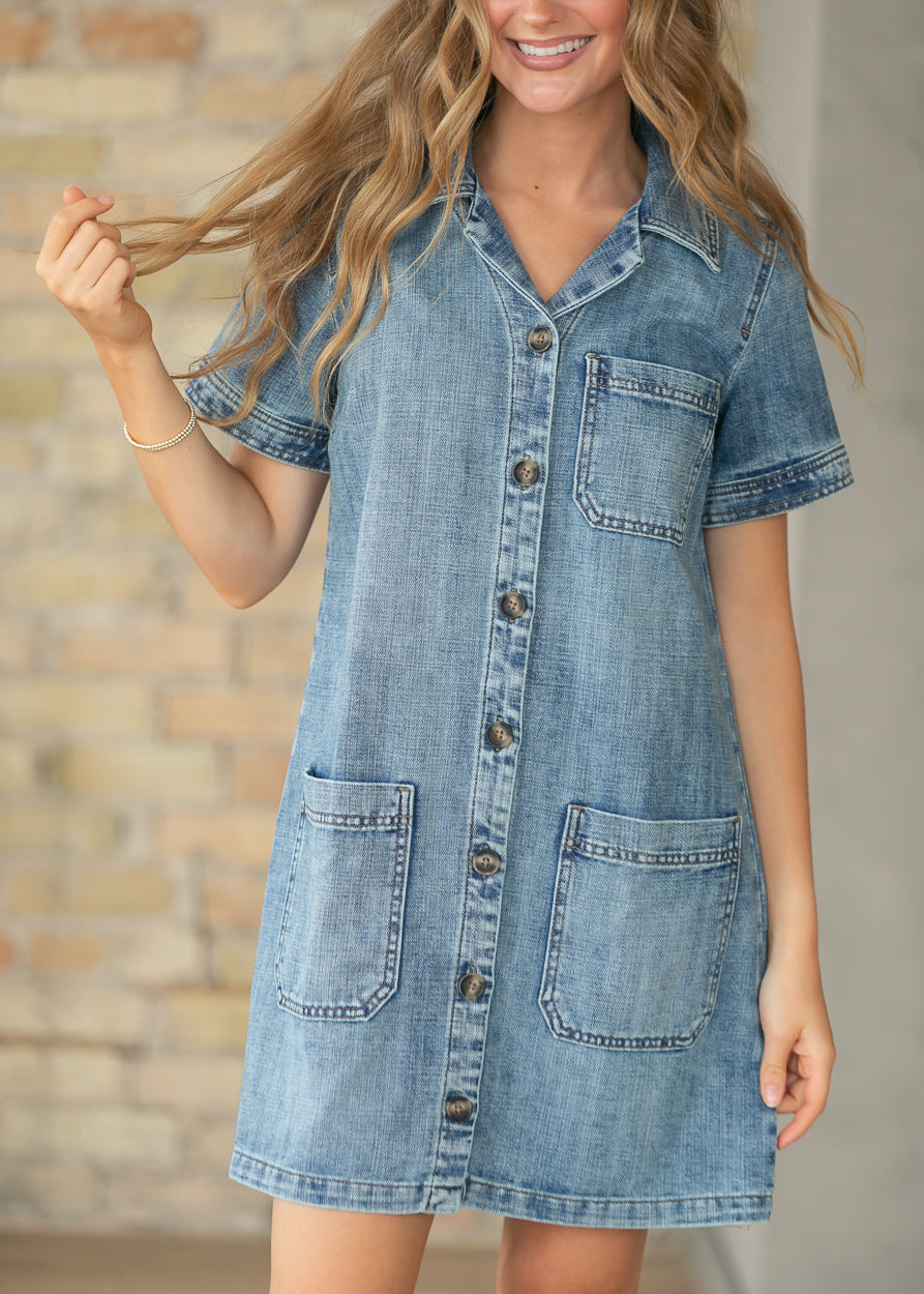 Medium wash denim midi dress with button front, short sleeves, and side pockets.
